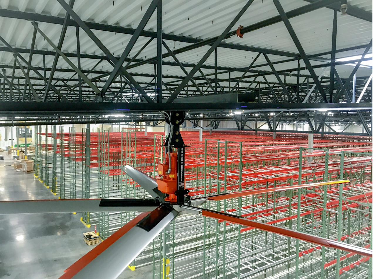 Large HVLS fan installed above warehouse pallet racking
